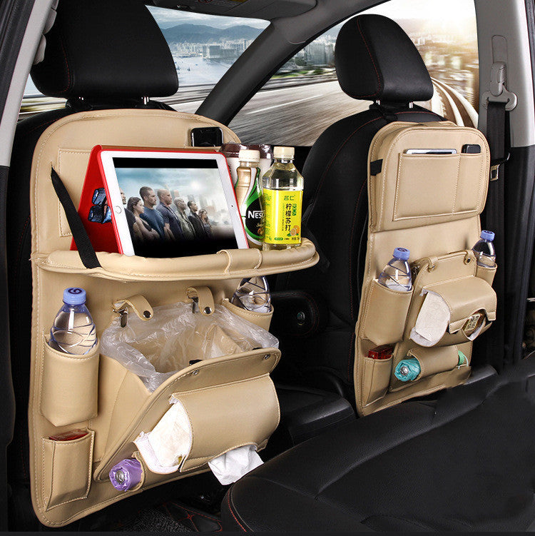 Beige cj Car Seat Organizer with multiple pockets holding bottles, tablet, tissues, and snacks on car backseat